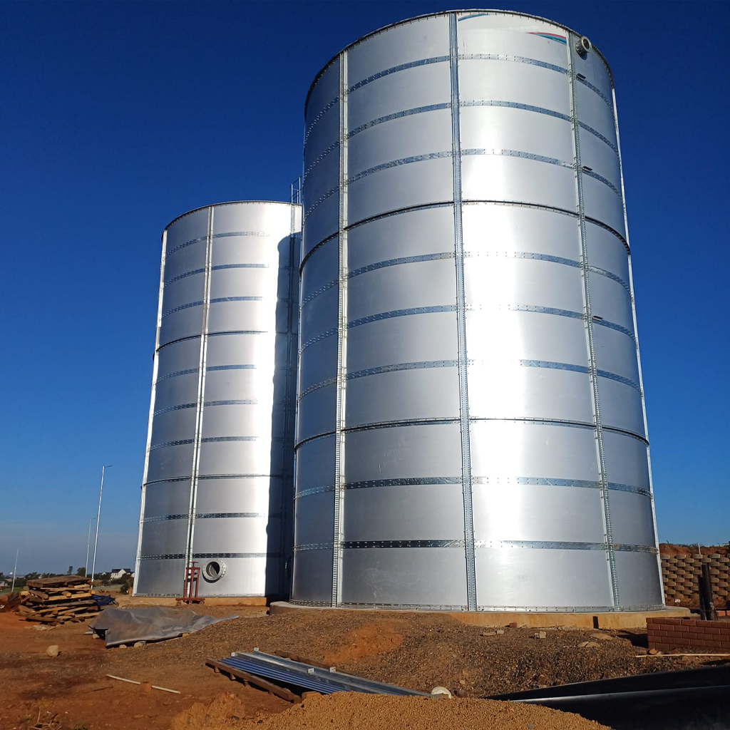 Three types of steel water storage tanks—cylindrical, modular sectional, and elevated—displayed side by side at an industrial facility.