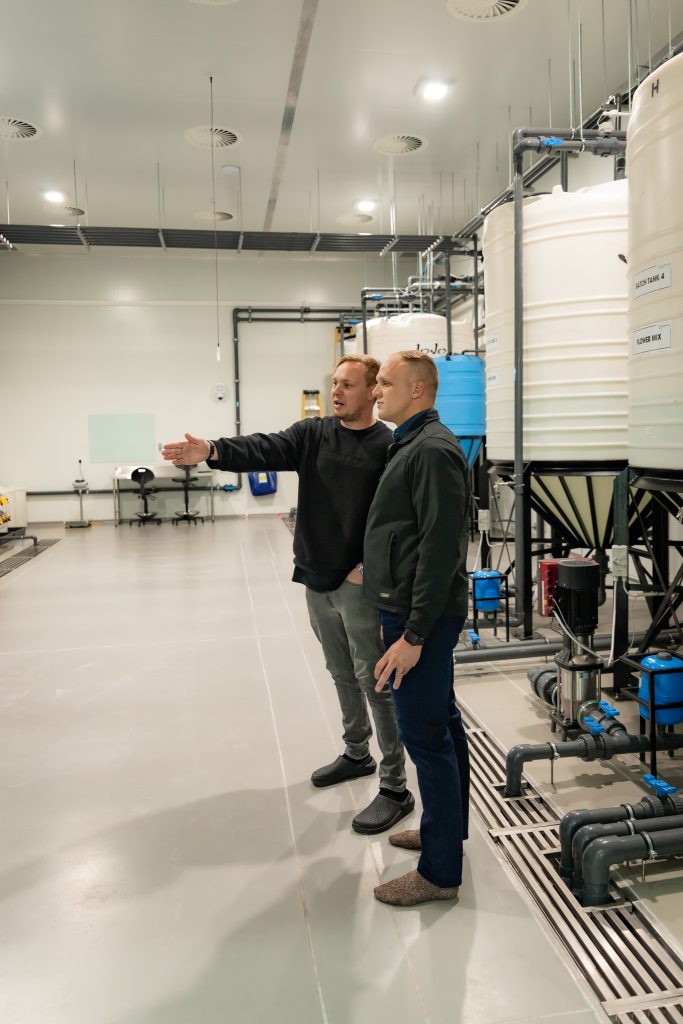 An iWaterManagement team member reviewing water treatment equipment indoors.