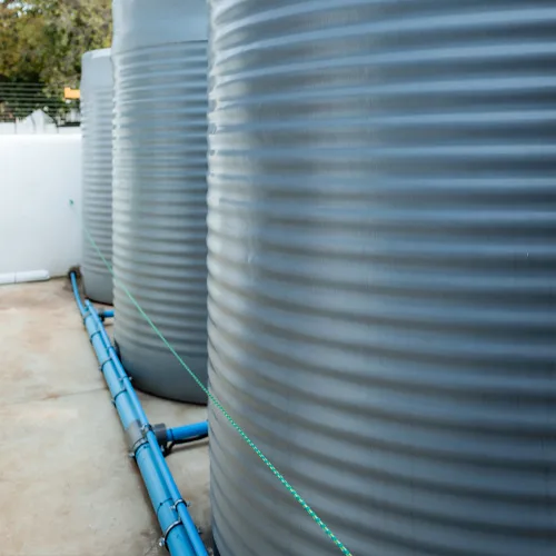 Modern South African retirement village with manicured gardens and a backup water storage tank on site.
