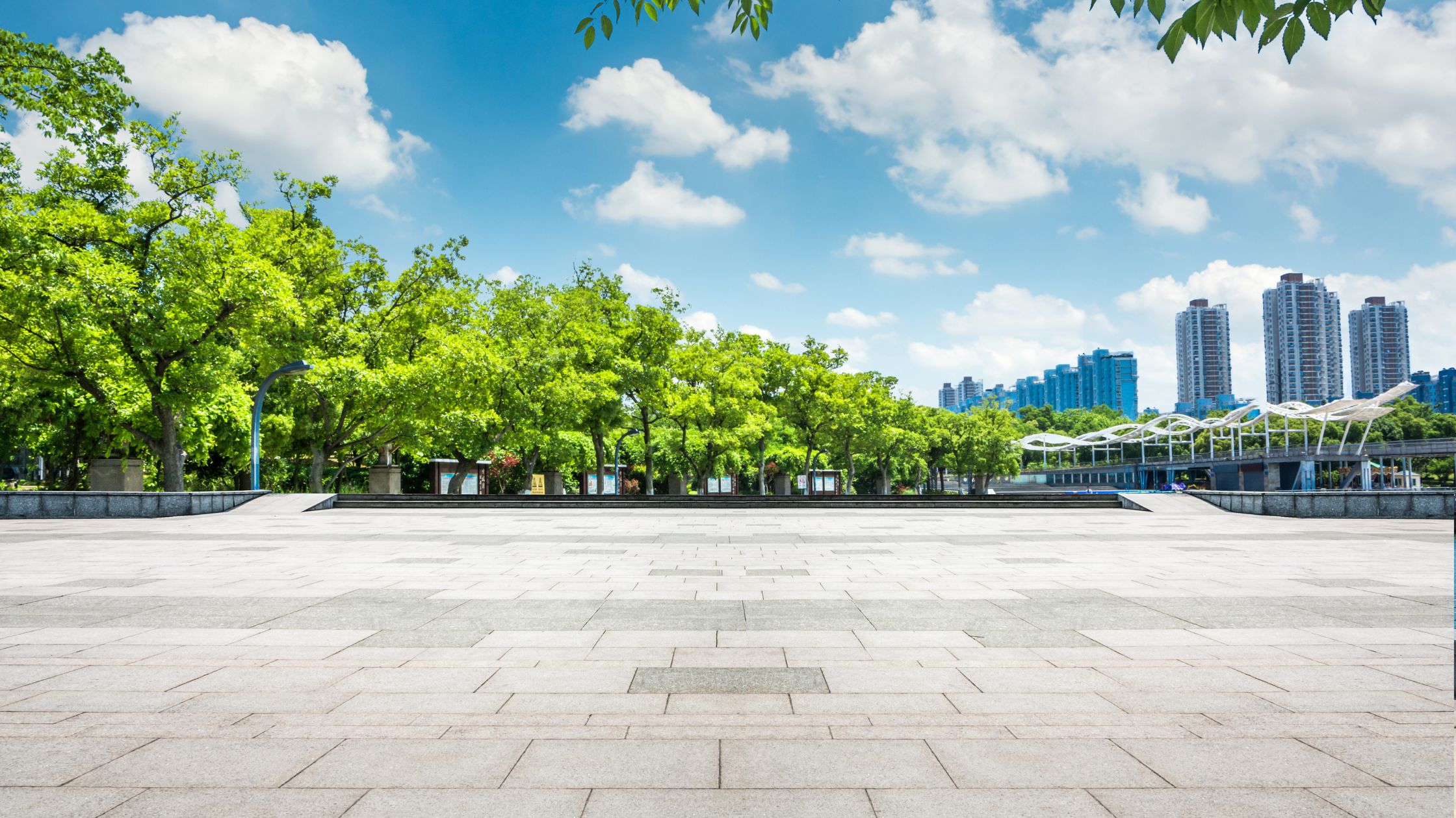 Modern business park with paved open space and green trees, representing eco-conscious infrastructure supported by sustainable water systems.